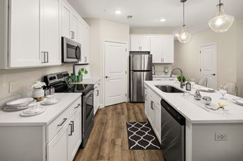 a spacious kitchen with white cabinets and stainless steel appliances